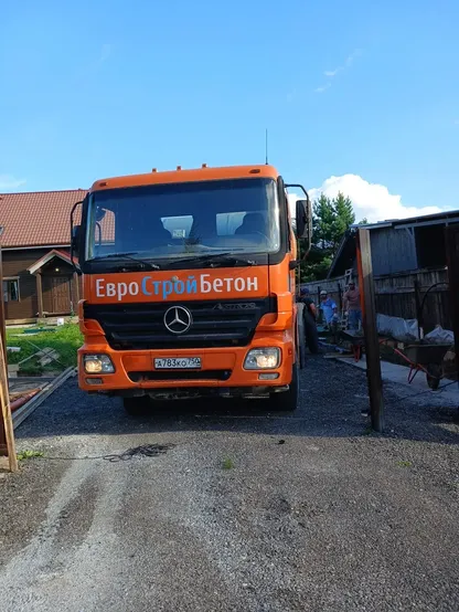 Оранжевый Mercedes-миксер ЕвроСтройБетон на въезде на объект