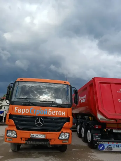Оранжевый Mercedes с красным тонаром на территории завода